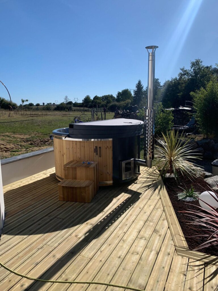 Bain nordique installé sur une terrasse en bois