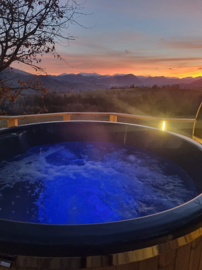 bain nordique avec LED allumés et coucher de soleil
